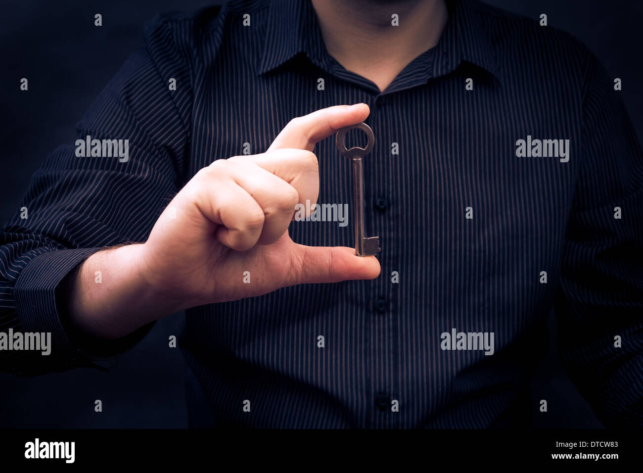 Man holding an old key in hand Stock Photo