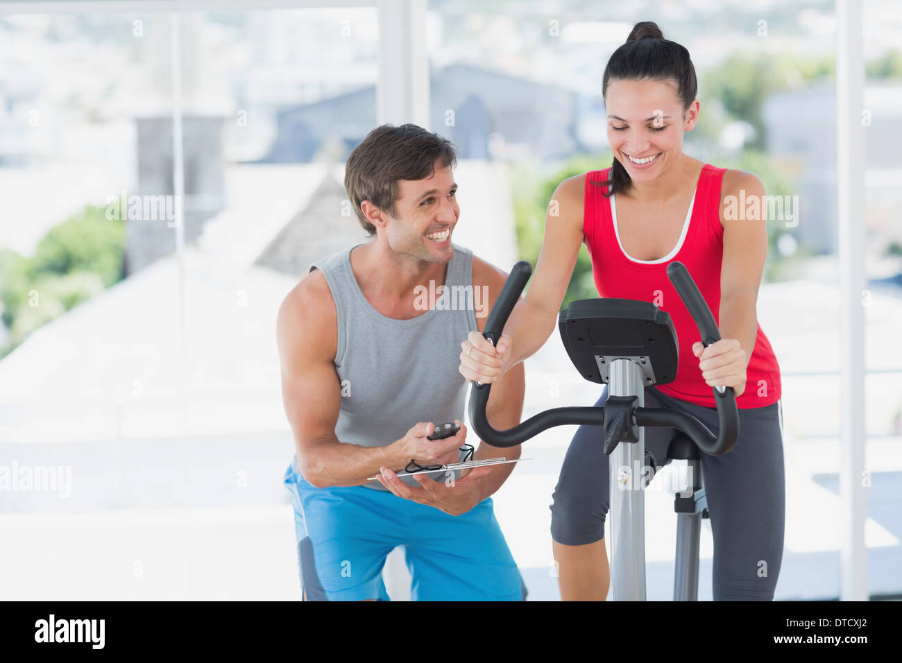Woman with male instructor working out at spinning class Stock Photo ...