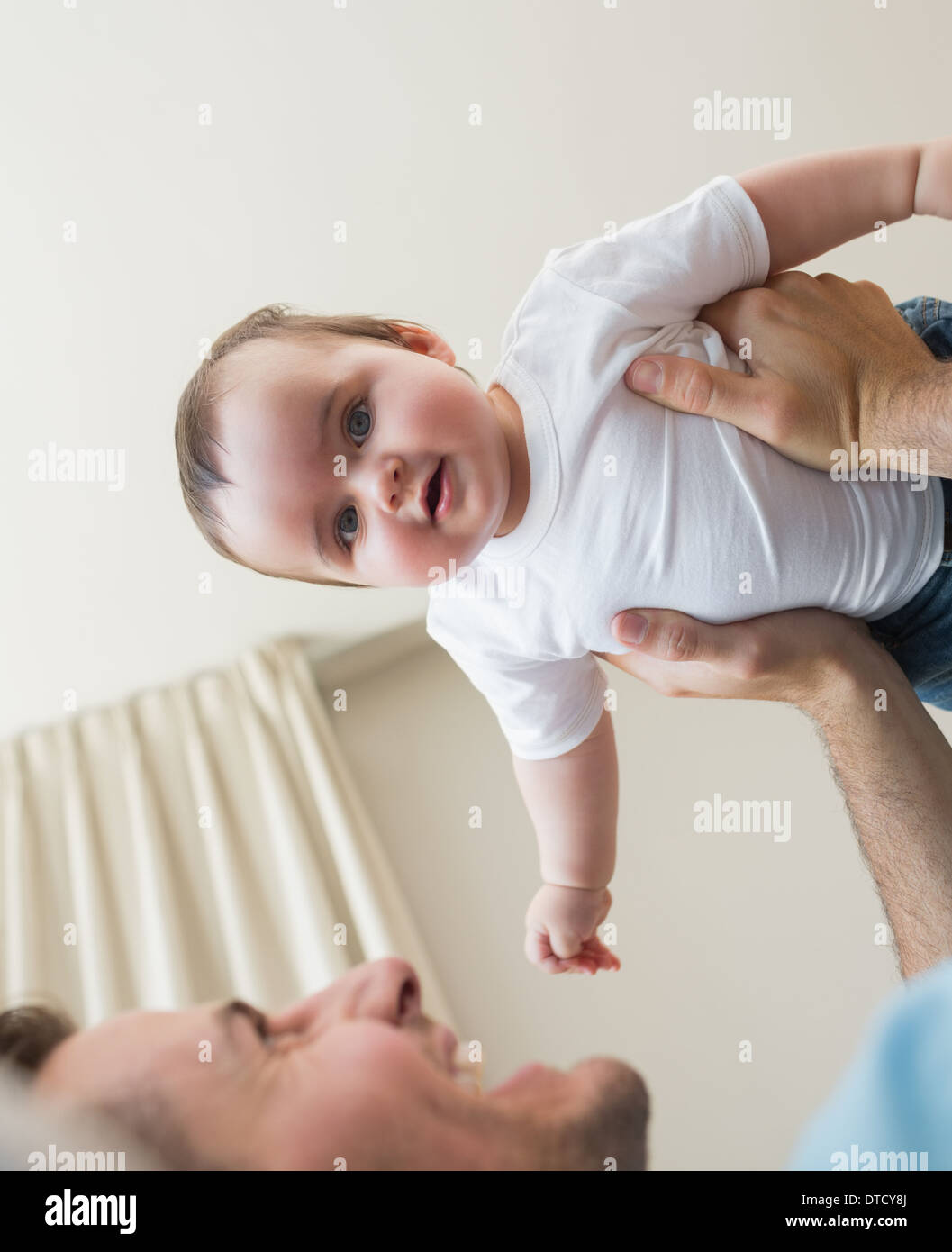 Adorable baby being carried by father Stock Photo