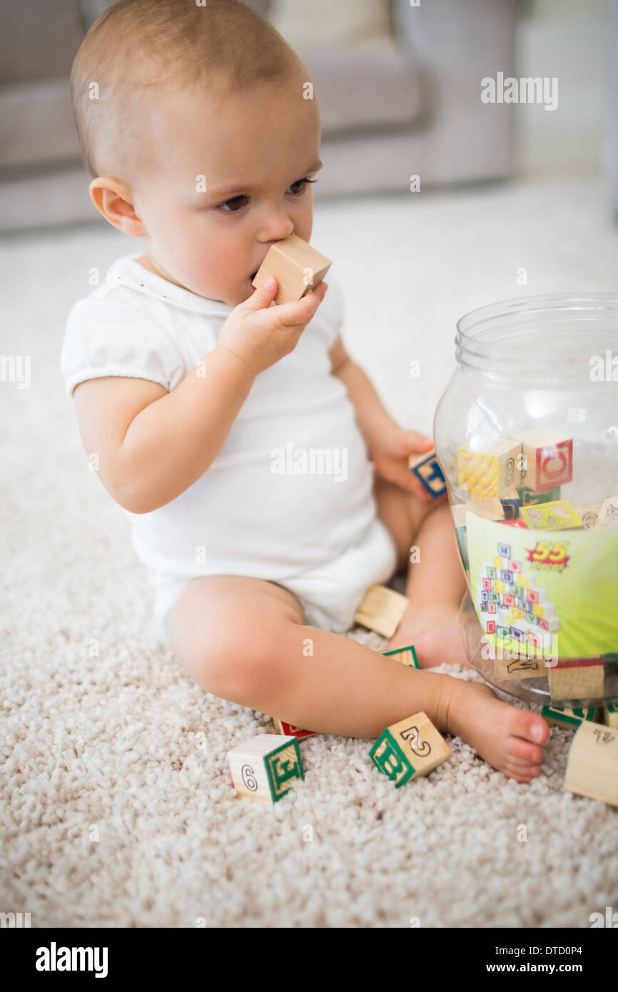 Cute little baby with toys sitting on carpet Stock Photo