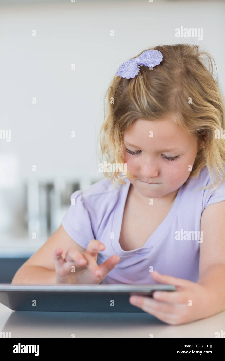 Girl using tablet computer at table Stock Photo