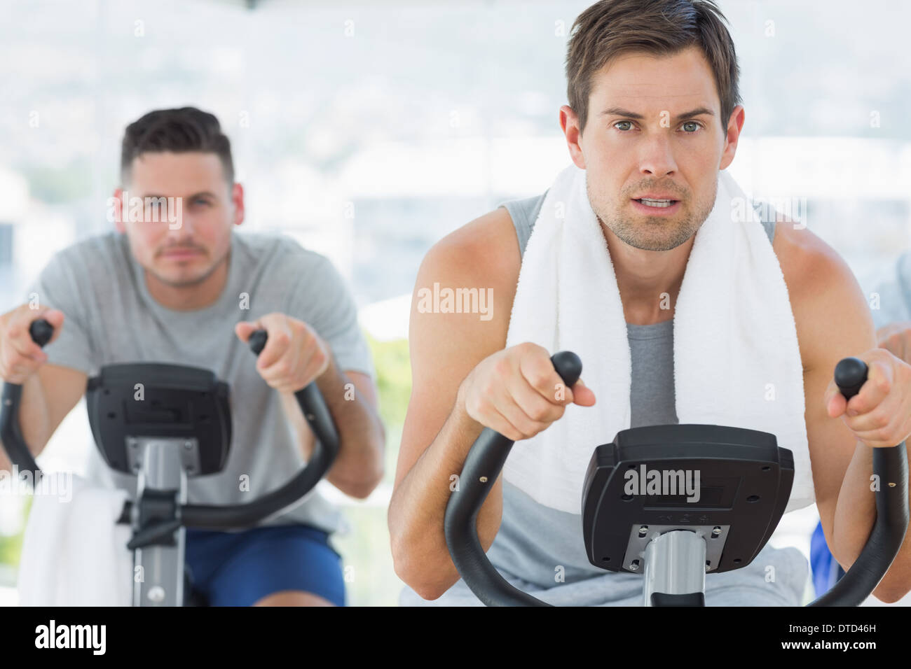 Determined men using exercise bikes Stock Photo - Alamy