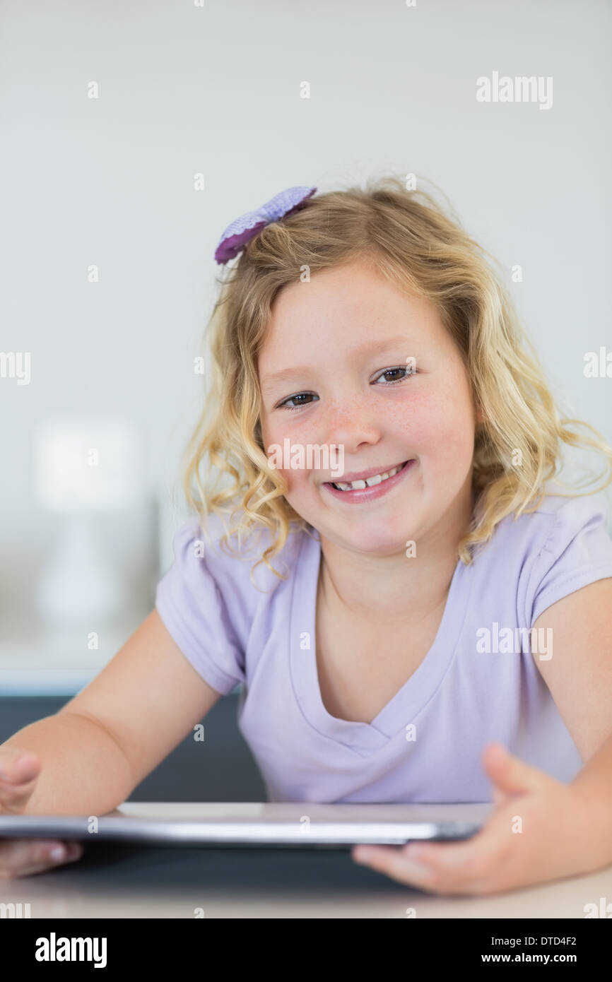 Smiling girl using tablet computer at table Stock Photo