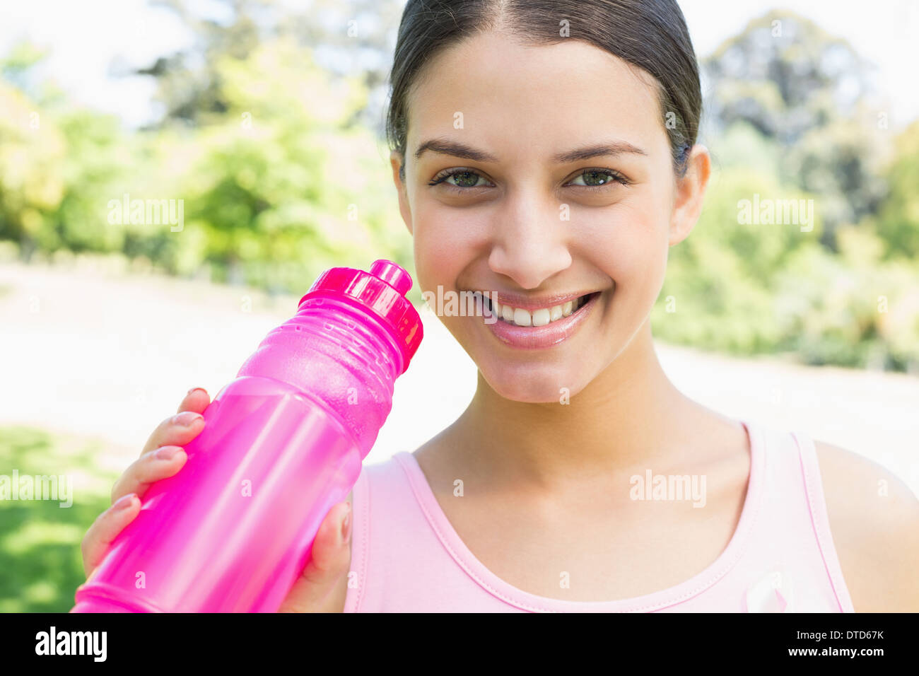 Happy sporty woman holding water bottle Stock Photo - Alamy