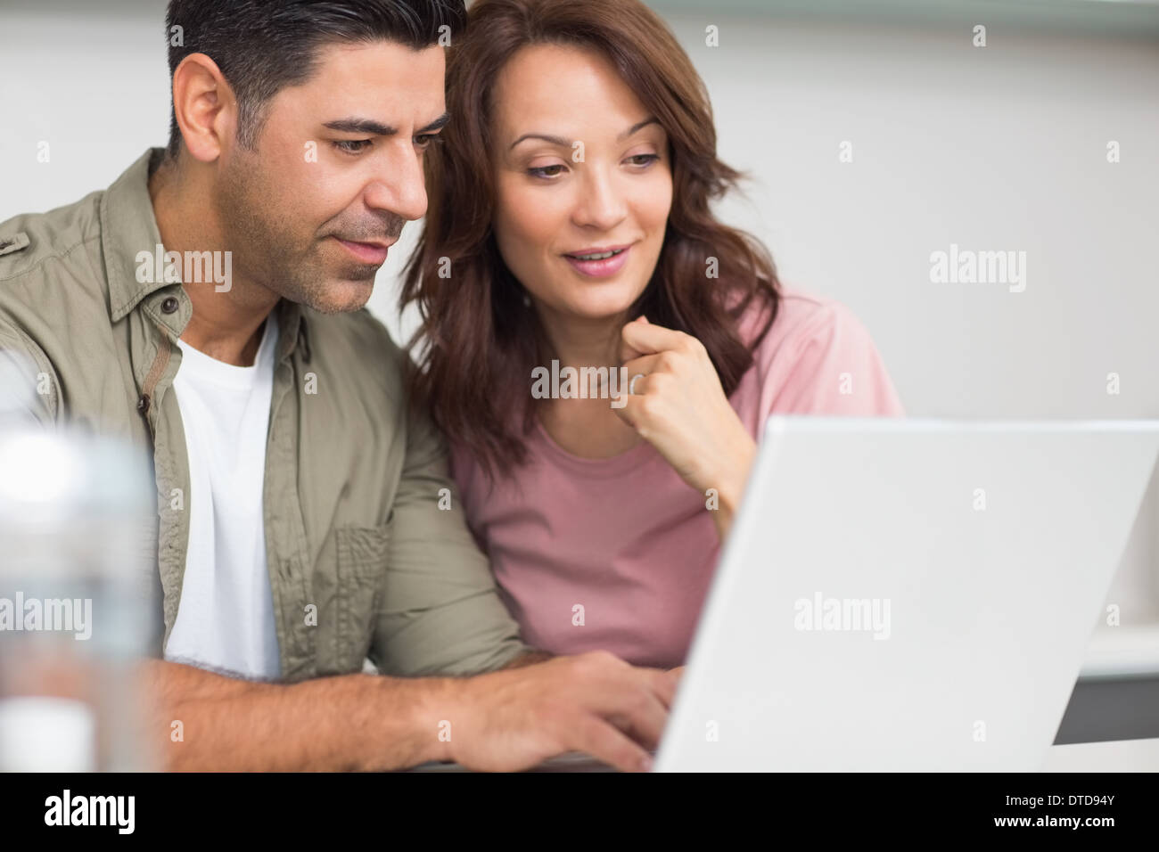 Couple using laptop in the kitchen Stock Photo