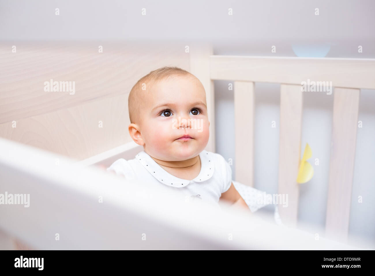 Closeup of a cute baby looking up in crib Stock Photo
