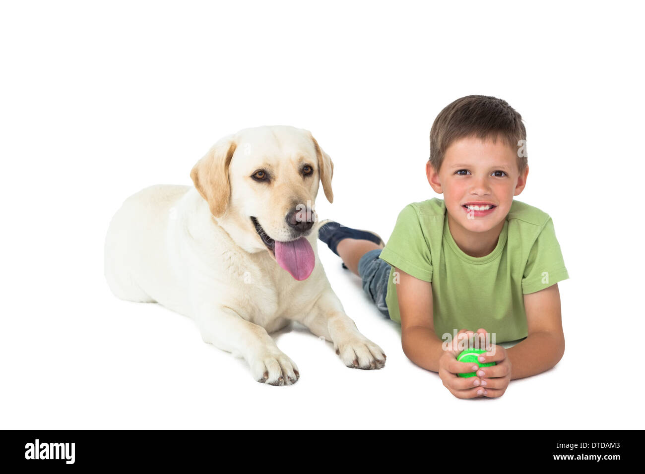 Cute little boy holding ball lying on floor with his labrador Stock Photo