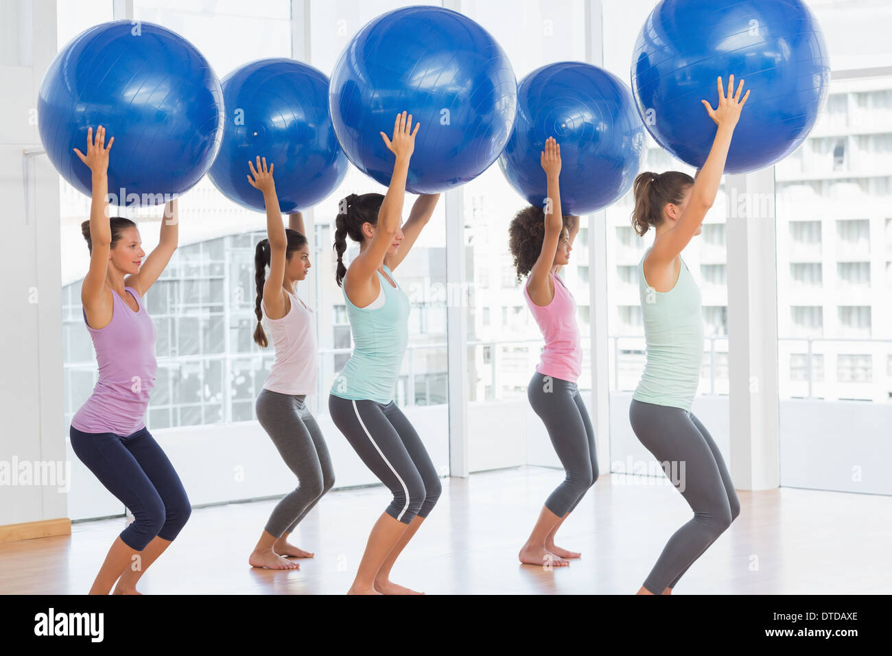Fit women holding blue fitness balls in exercise room Stock Photo - Alamy