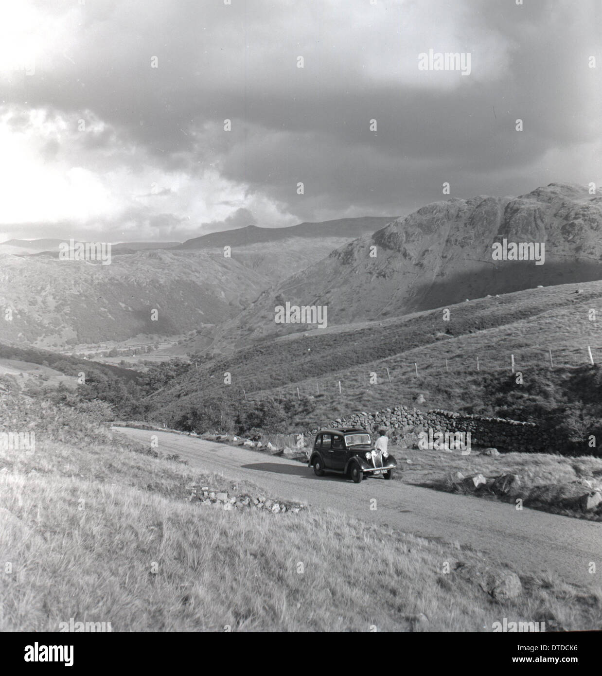 Historical picture from 1950s showing a car parked on a country road