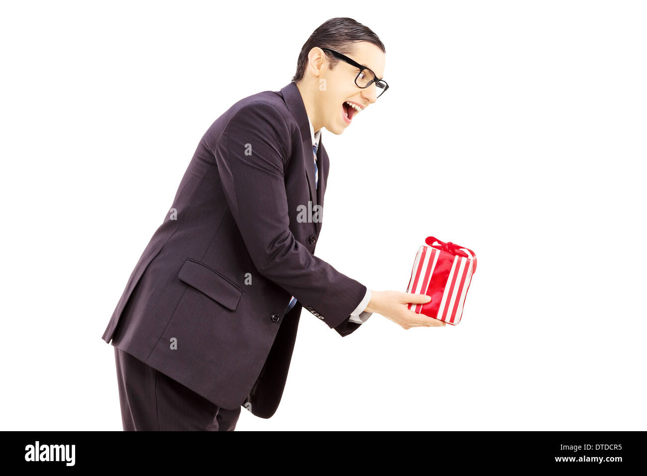 Excited young man in black suit giving a present Stock Photo