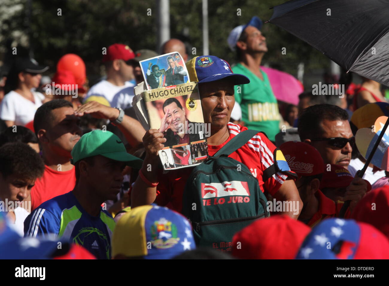 Caracas, Venezuela. 15th Feb, 2014. A demonstrator holds images of late President Hugo Chavez, during the "March for Peace", called on Friday by Venezuelan President Nicolas Maduro, in the city of Caracas, capital of Venezuela, on Feb. 15, 2014. Credit:  AVN/Xinhua/Alamy Live News Stock Photo