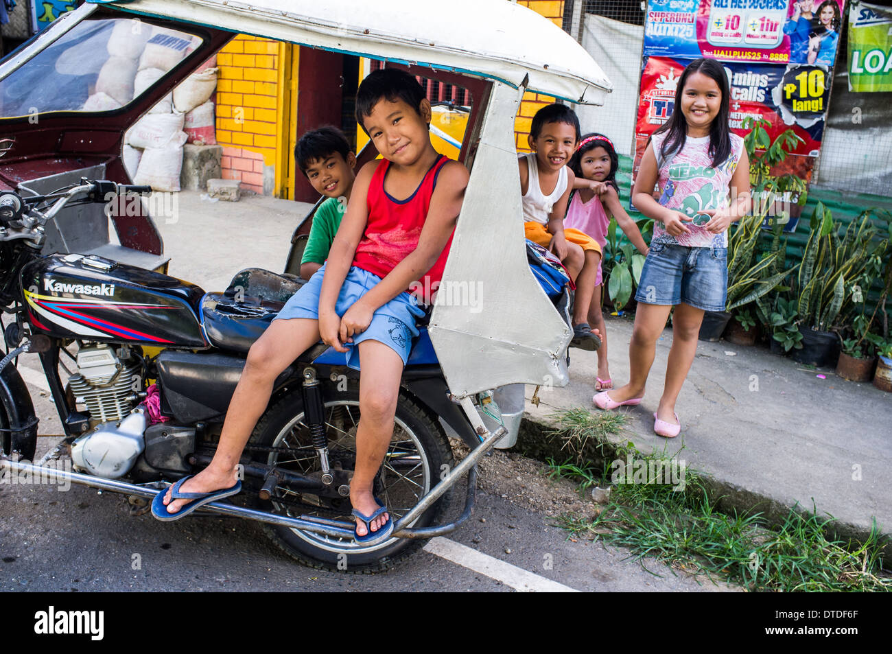 street children sitting on a tricycle, Philippines Stock Photo