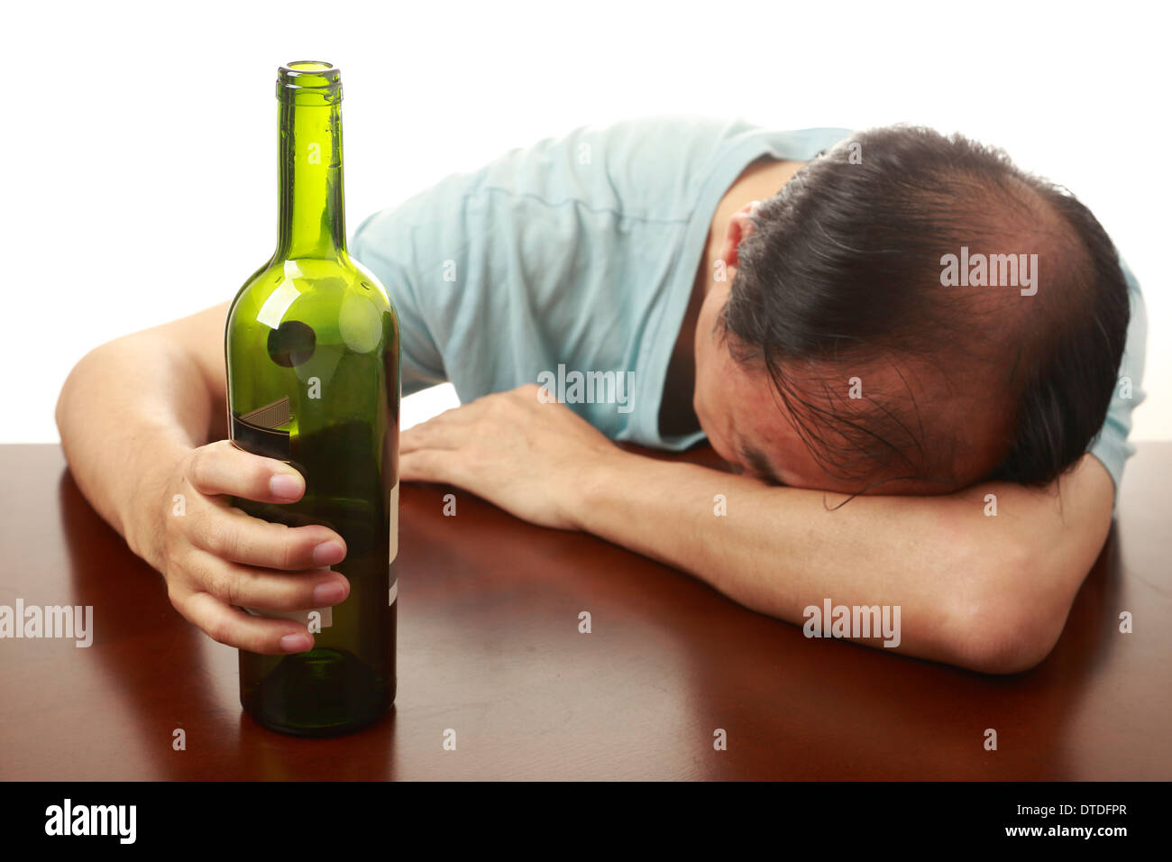 Asian man sleeping on a table after drinking too much Stock Photo