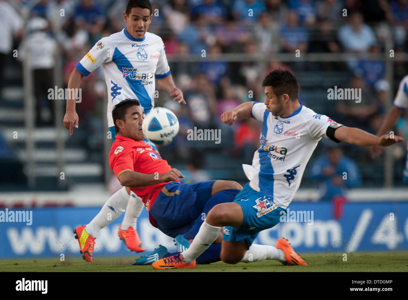 Mexico City, Mexico. 15th Feb, 2014. Marco Fabian (C) of Cruz Azul vies for the ball with Luis Miguel Noriega (R) of Puebla during the 2014 MX League Closing Tournament at Azul Stadium in Mexico City, capital of Mexico, on Feb. 15, 2014. Credit:  Pedro Mera/Xinhua/Alamy Live News Stock Photo