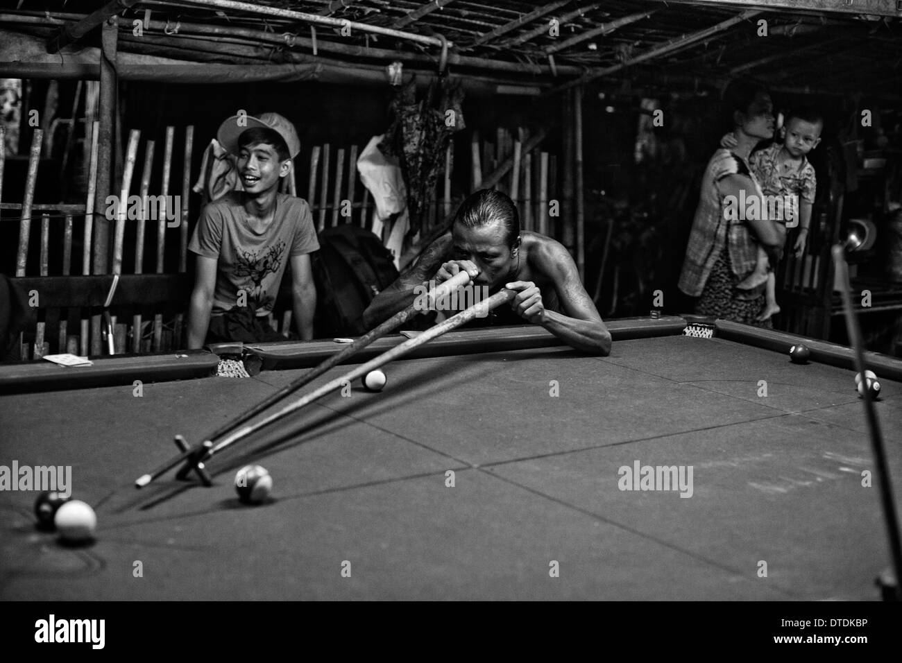A group of men play pool in a slum in Yangon, Myanmar, Tuesday, May 7, 2013. (Photo/Arturo Rodriguez) Stock Photo