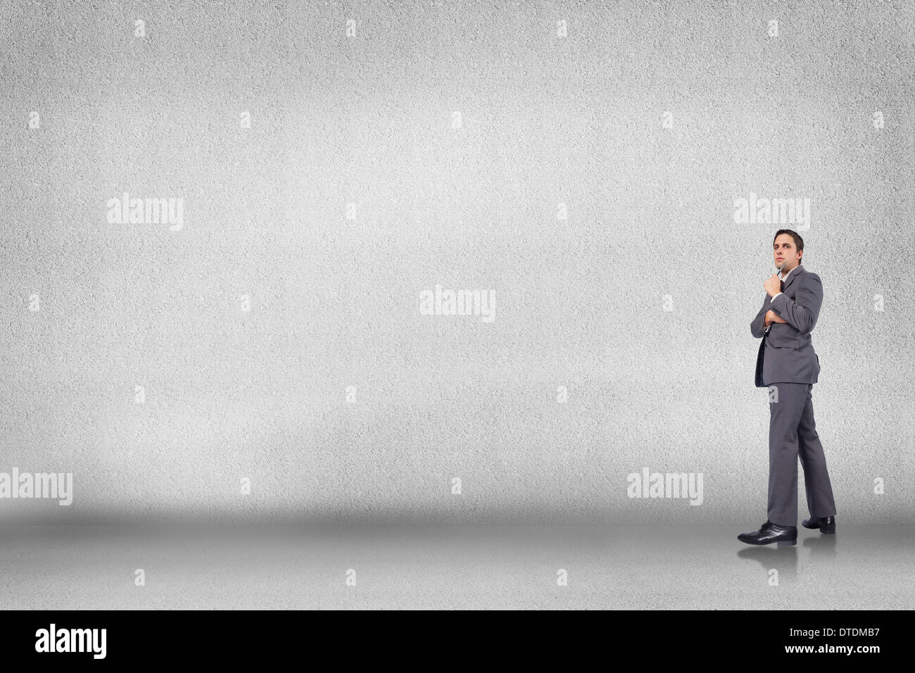 Composite image of thoughtful businessman holding pen to chin Stock Photo
