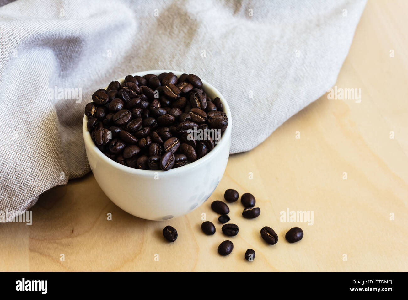 https://c8.alamy.com/comp/DTDMCJ/cup-full-of-coffee-beans-on-the-cloth-sack-DTDMCJ.jpg