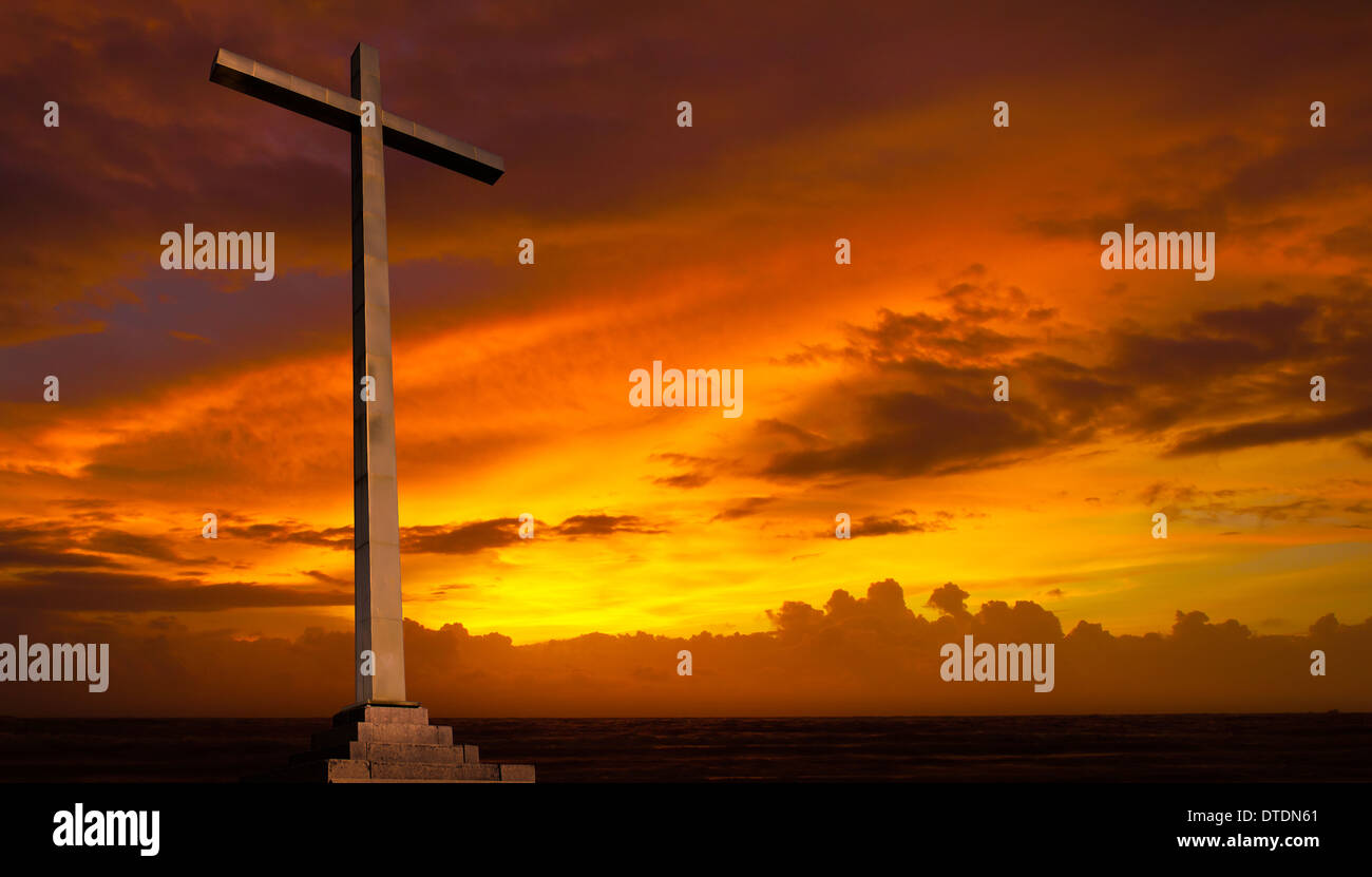 Christian cross on sunset sky. Religion background. Stock Photo