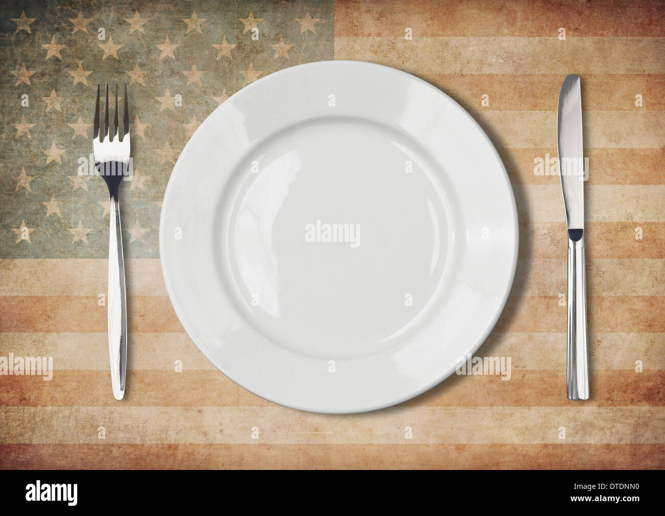 Plate, fork and knife on old USA flag Stock Photo