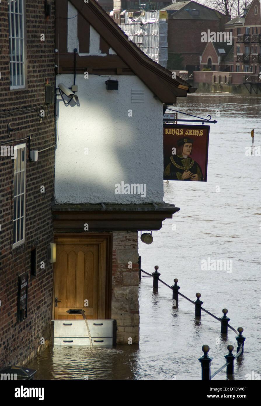 York, UK. 16th February 2014. The Kings Arms public House on King's Staith in York flooded by the river Ouse on the 16th of February. York is regularly flooded by the River Ouse. Flood defences and stategies are well rehearsed in the city, as can be seen by the barriers and the hose pipe poking through the letter box pumping water out. Credit:  CHRIS BOSWORTH/Alamy Live News Stock Photo