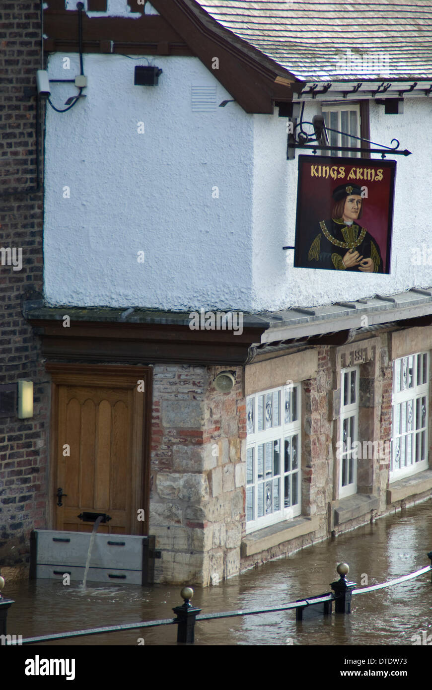 York, UK. 16th February 2014. The Kings Arms public House on King's Staith in York flooded by the river Ouse on the 16th of February. York is regularly flooded by the River Ouse. Flood defences and stategies are well rehearsed in the city, as can be seen by the barriers and the hose pipe poking through the letter box pumping water out. Credit:  CHRIS BOSWORTH/Alamy Live News Stock Photo