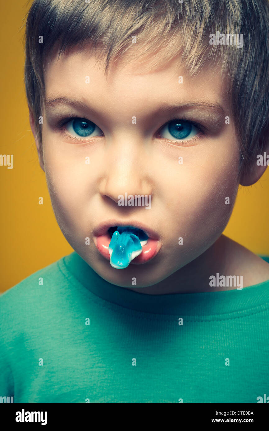Young boy indoors eating a candy. Stock Photo
