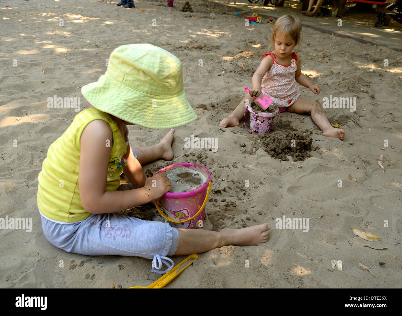 Three and five year old girls playing in the sandbox Stock Photo Alamy