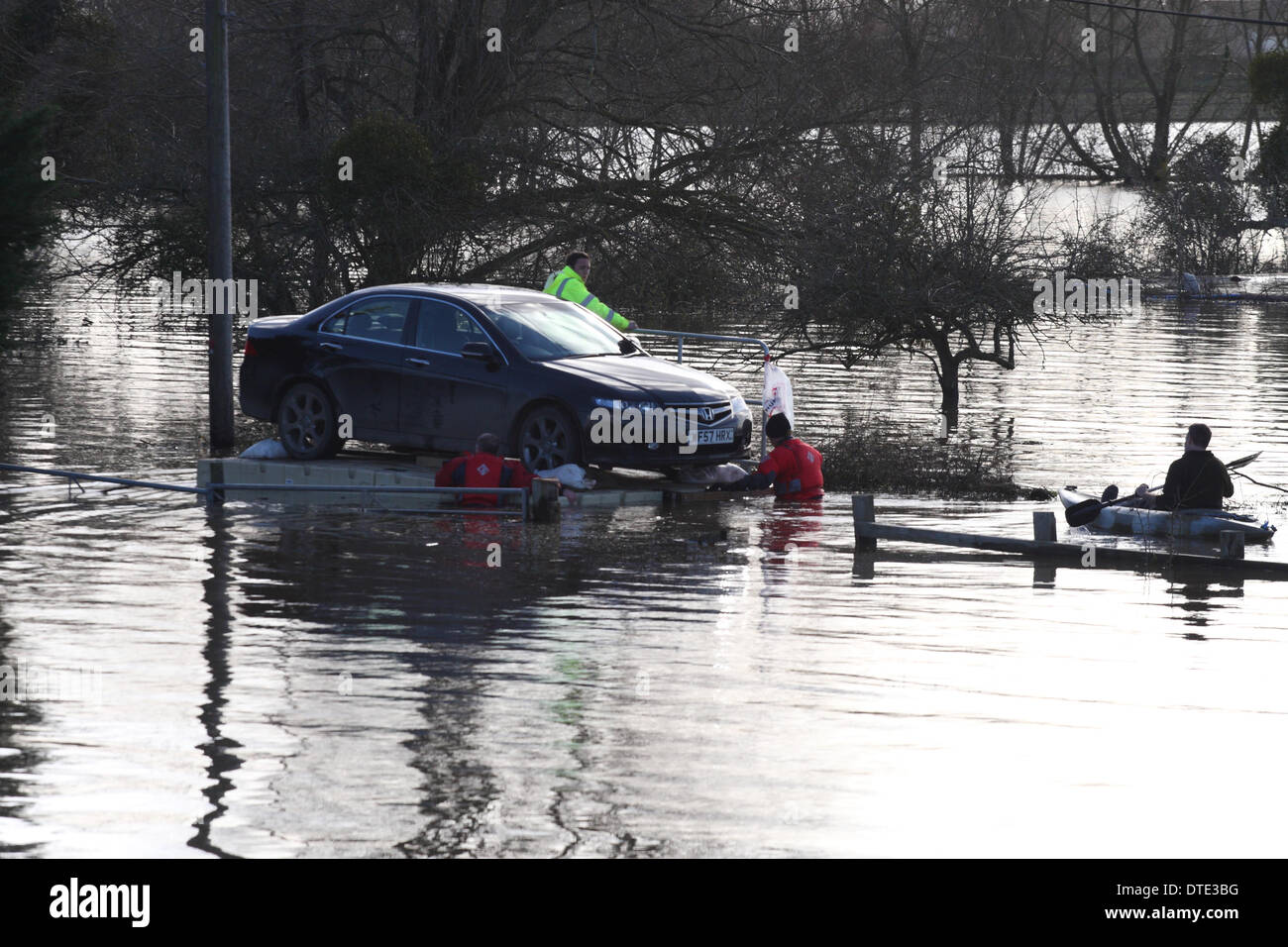 Burrowbridge, Somerset Levels Sunday 16th February 2014 – Unusual car rescue - volunteers use a floating pontoon to float a Honda Accord car from a cut off property - the pontoon was manhandled slowly and carefully to the nearest dry road. Stock Photo