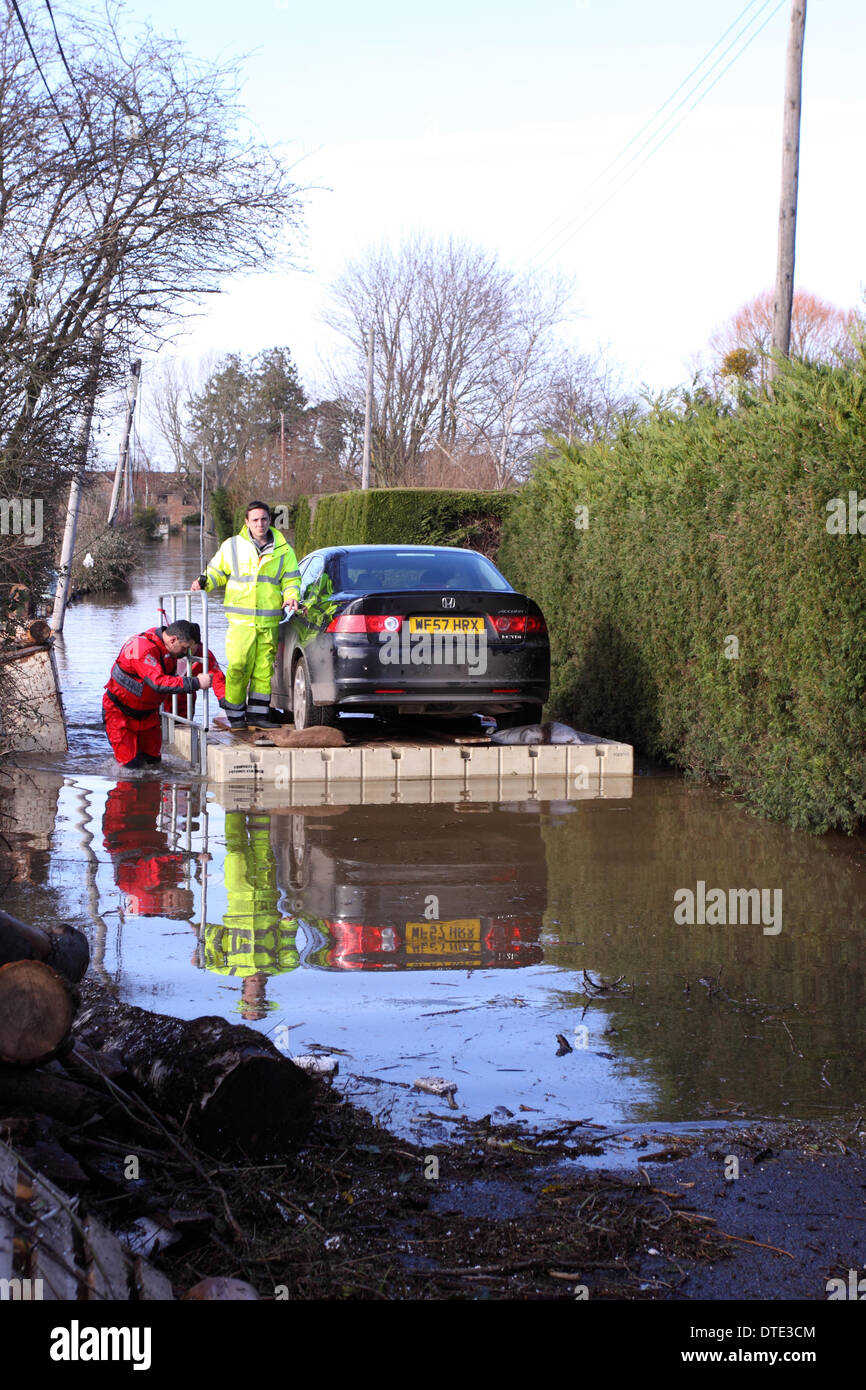 Burrowbridge, Somerset Levels Sunday 16th February 2014 – Unusual car rescue - volunteers use a floating pontoon to float a Honda Accord car from a cut off property - the pontoon was manhandled slowly and carefully to the nearest dry road. Stock Photo