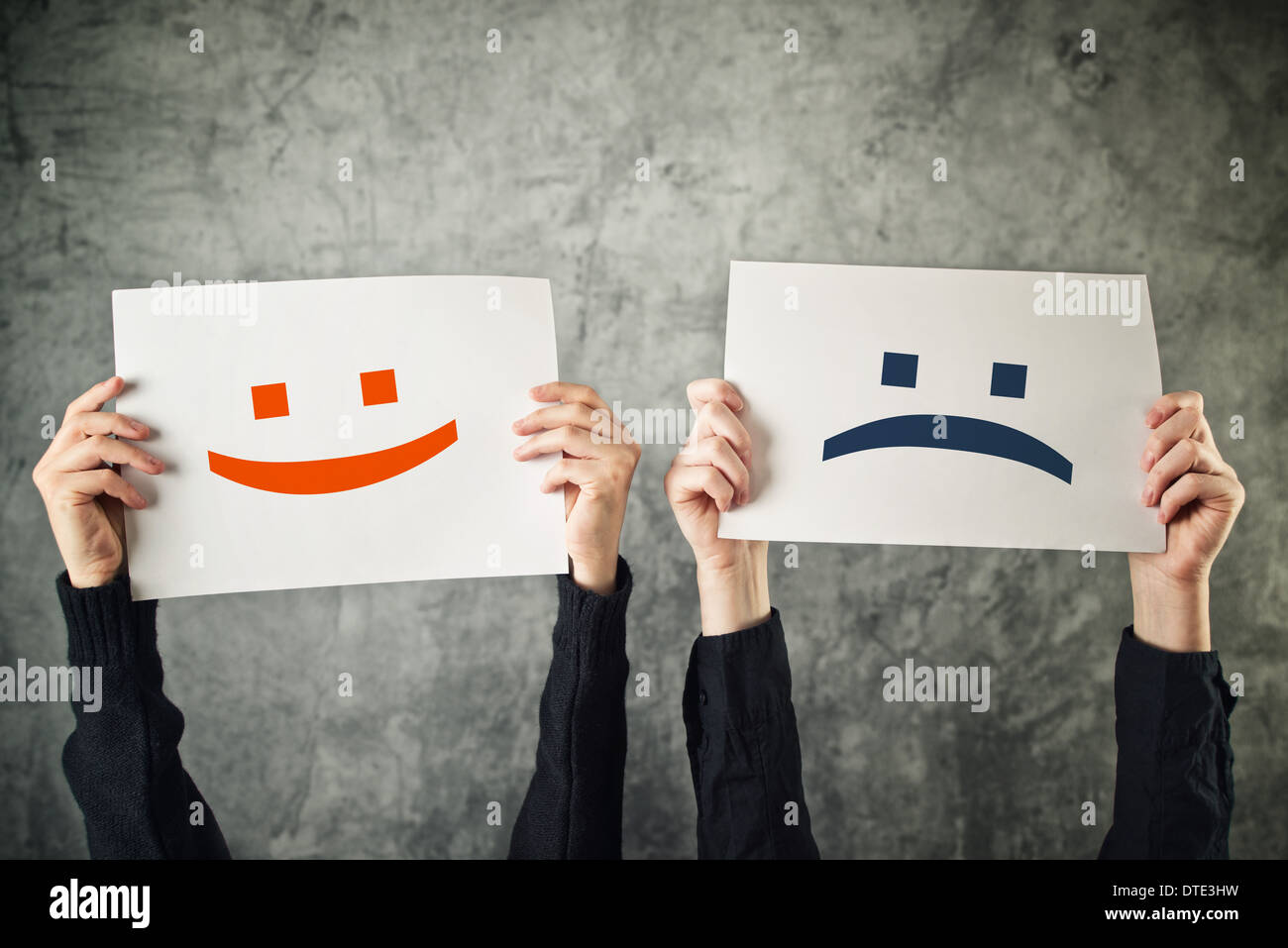 Happy and sad face. Women holding papers with happy and sad emoticons. Stock Photo