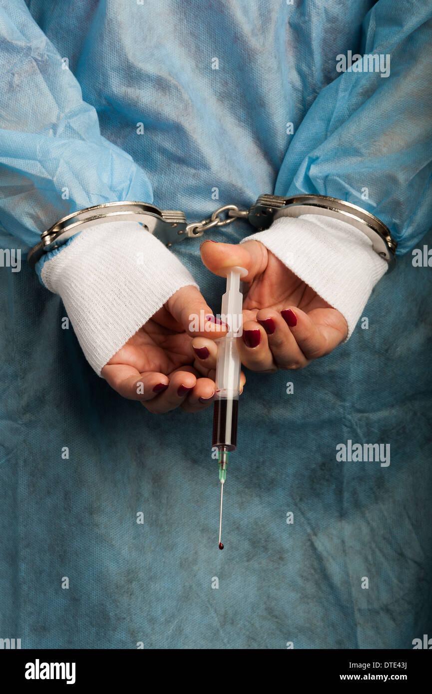 Criminal handcuffed medical person with bloody injector in hand Stock Photo