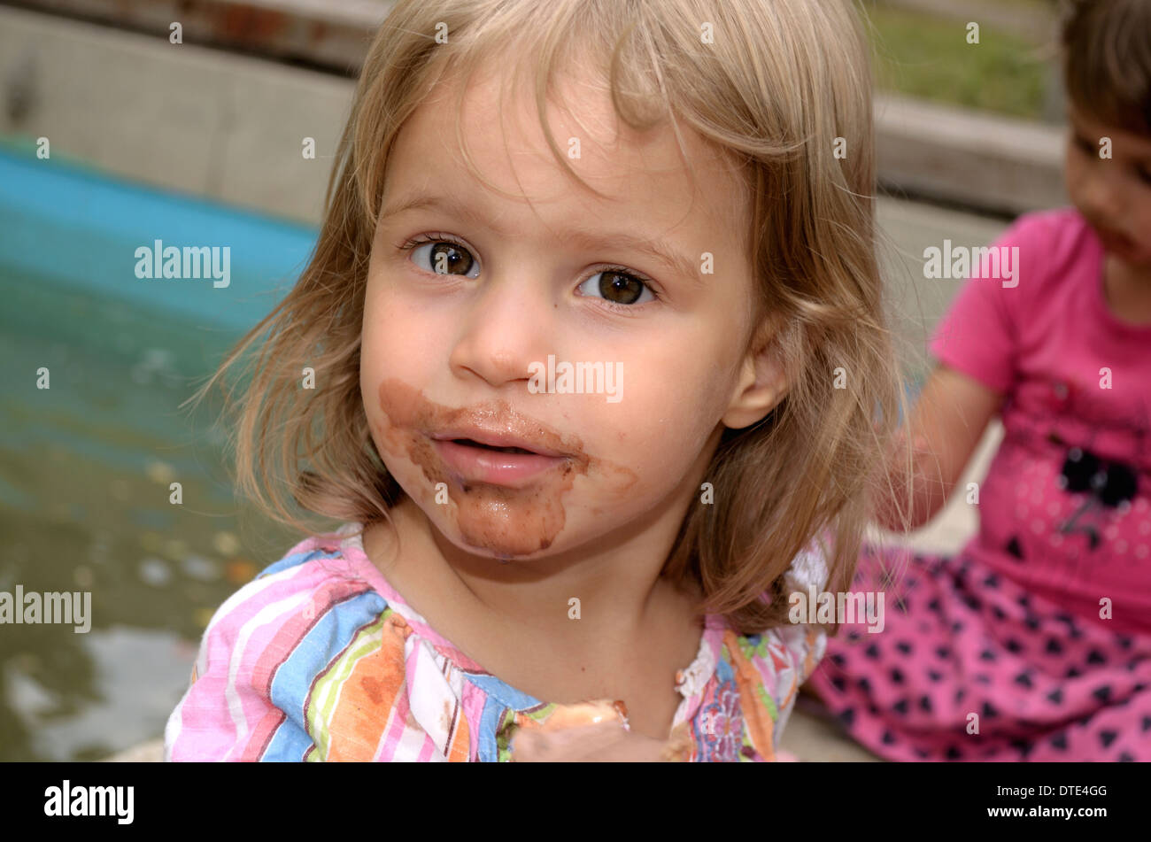 2 year old girl smudged from licking ice cream Stock Photo