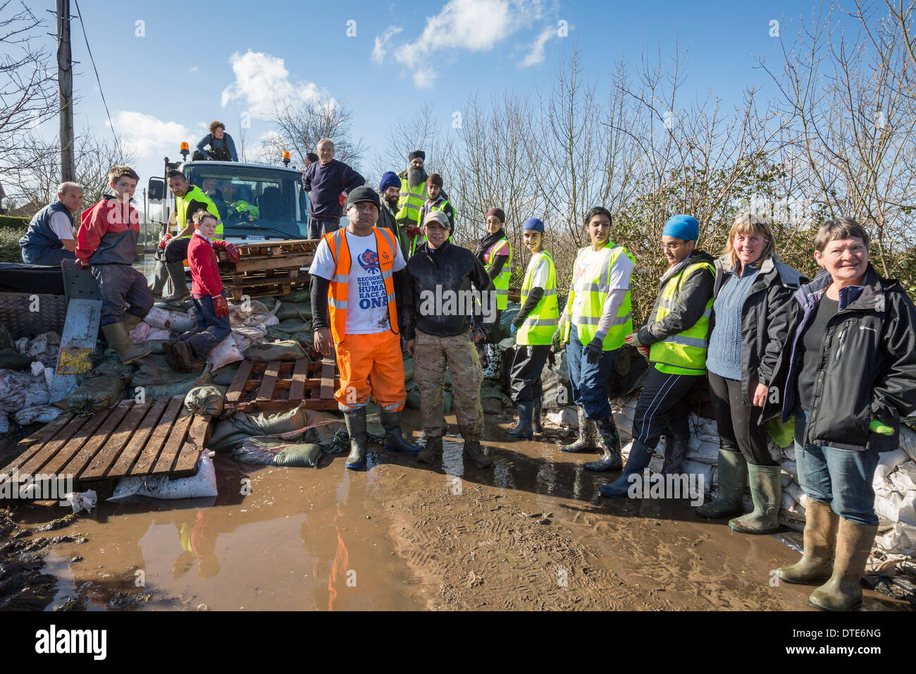 Volunteers from the Khalsa Aid meet up with staff from the Environment Agency on February 16, 2014 in the village of Moorland. They help distribute supplies of oil, water, food and sand bags to those residents who remain. The Khalsa Aid organisation is a charity run by volunteers from the Sikh community to bring humanitarian relief around the world. This is the worst flooding in Somerset since records began. Stock Photo