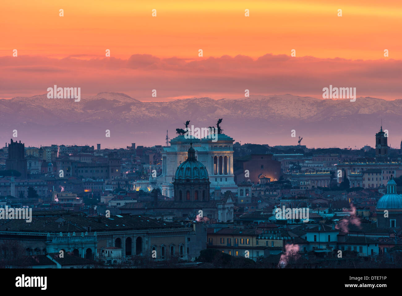 Rome at sunrise in a cloudy day showing Vittorio Emanuele II monument with mountains in the background Stock Photo