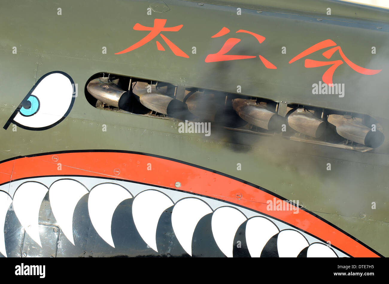 This shark mouth nose art is on a P-40 KittyHawk, seen here starting up with clouds of exhaust smoke. Hood Aerodrome, New Zealand Stock Photo