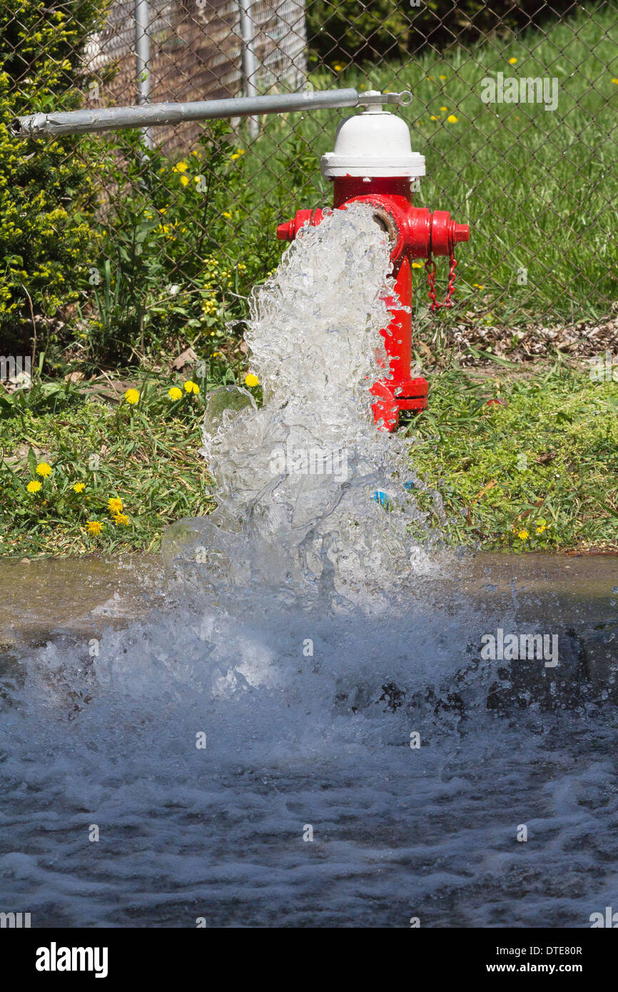 Damaged fire hydrant splashes wather on the city street.Closeup of