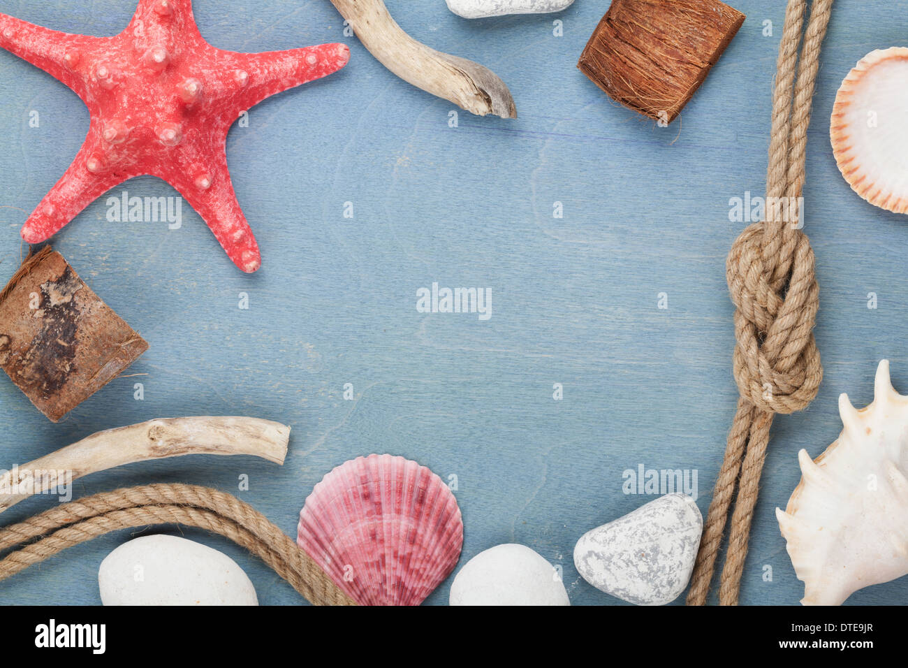 Sea travel frame decor with seashells and rope over wooden background Stock Photo