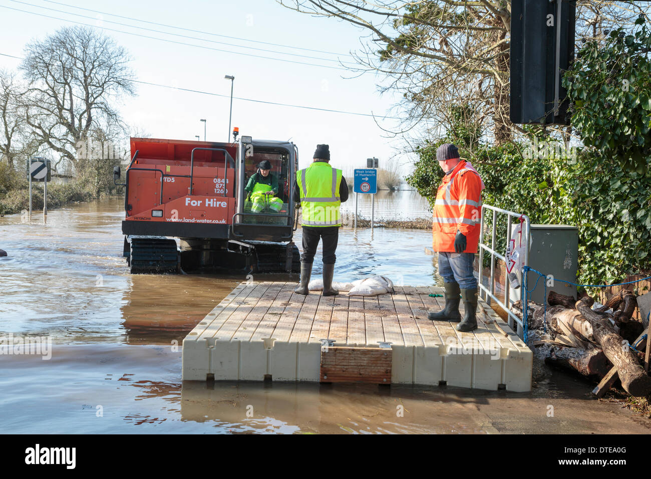 Burrowbridge, UK. 16th Feb, 2014. Workers make use of specialised vehicles during the heavy flooding at Burrowbridge on the Somerset Levels on February 16, 2014. Vehicles suitable for use in deep water are being used to remove obstacles such as tree trunks and telegraph poles from the water so that aid can be distributed to local residents. The A361 is a major arterial route across the Somerset Levels and has just experienced the worst flooding in living history and has been underwater now for seven weeks. Credit:  Nick Cable/Alamy Live News Stock Photo