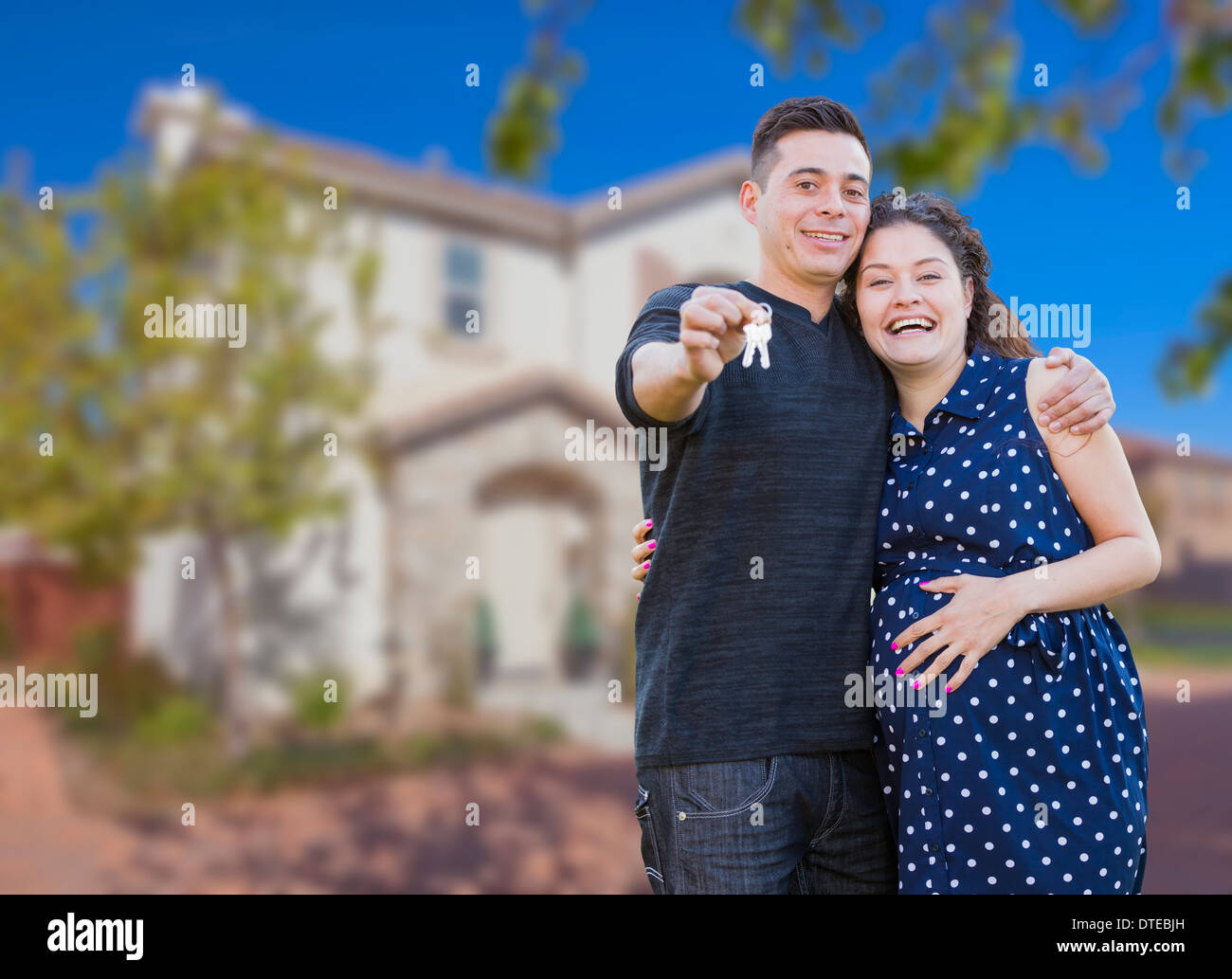 Happy Hispanic Couple In Front of New Home Showing Off Their House Keys ...