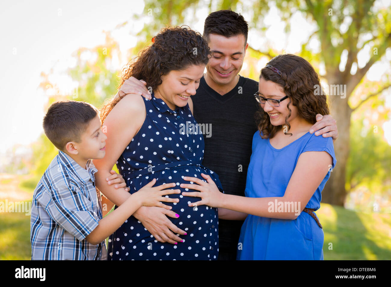 Hispanic Family Hands on Pregnant Mother Tummy Feeling Baby Kick