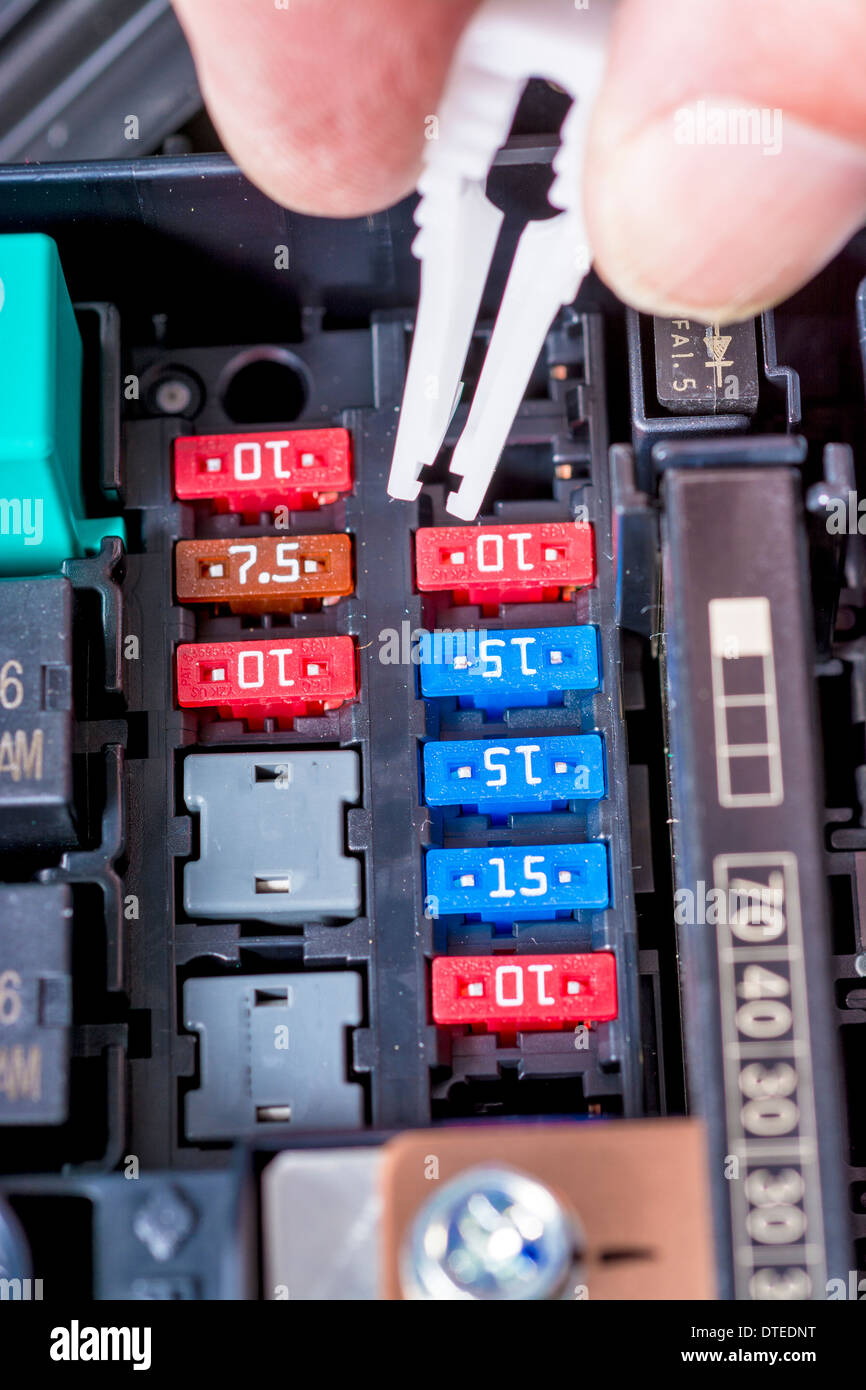Pulling a fuSe out of a cars fuse box - Stock Image