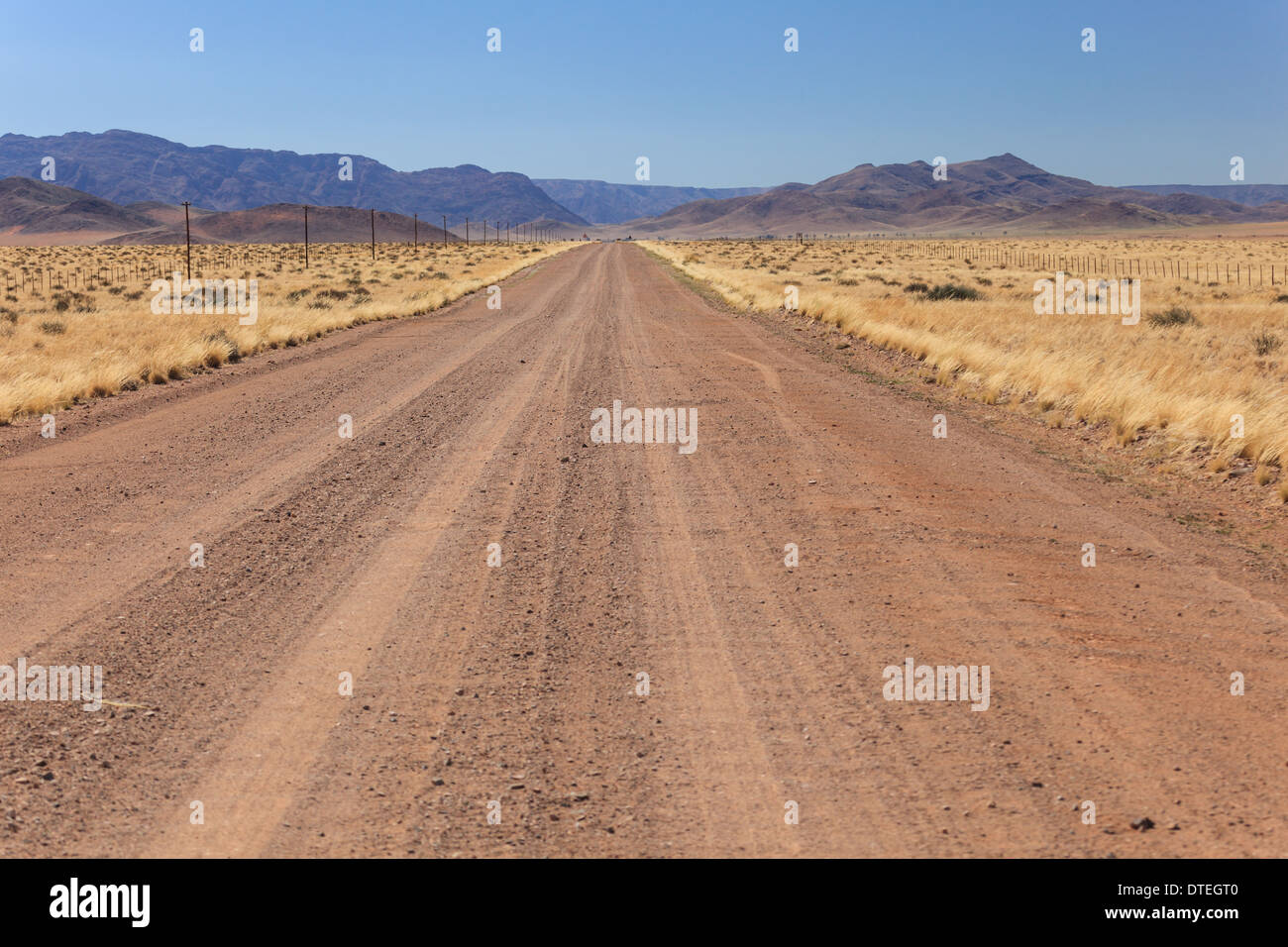Miles of straight dirt road through the National Park in Northern Namibia Africa Stock Photo