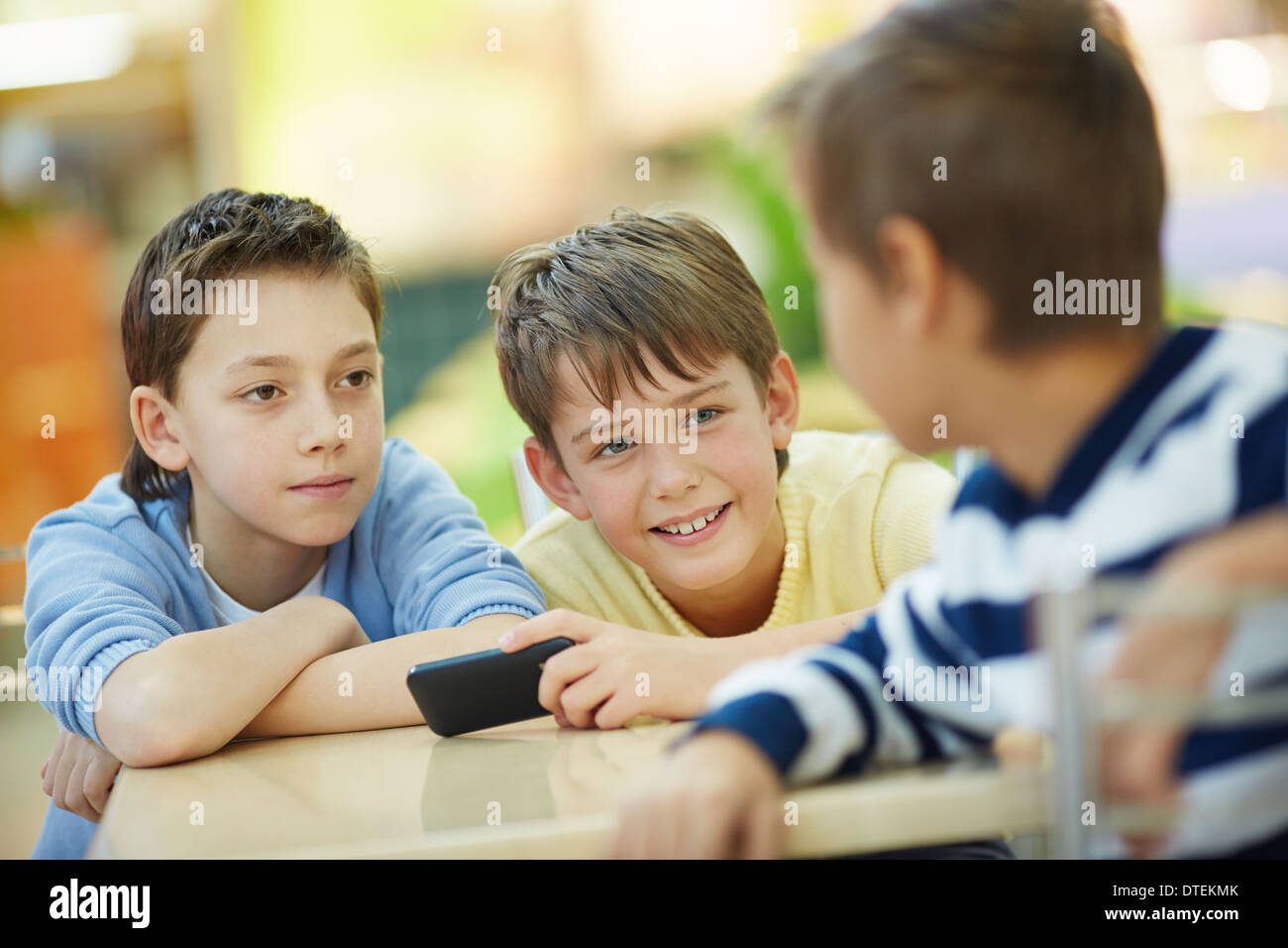 Three boys talking indoors Stock Photo