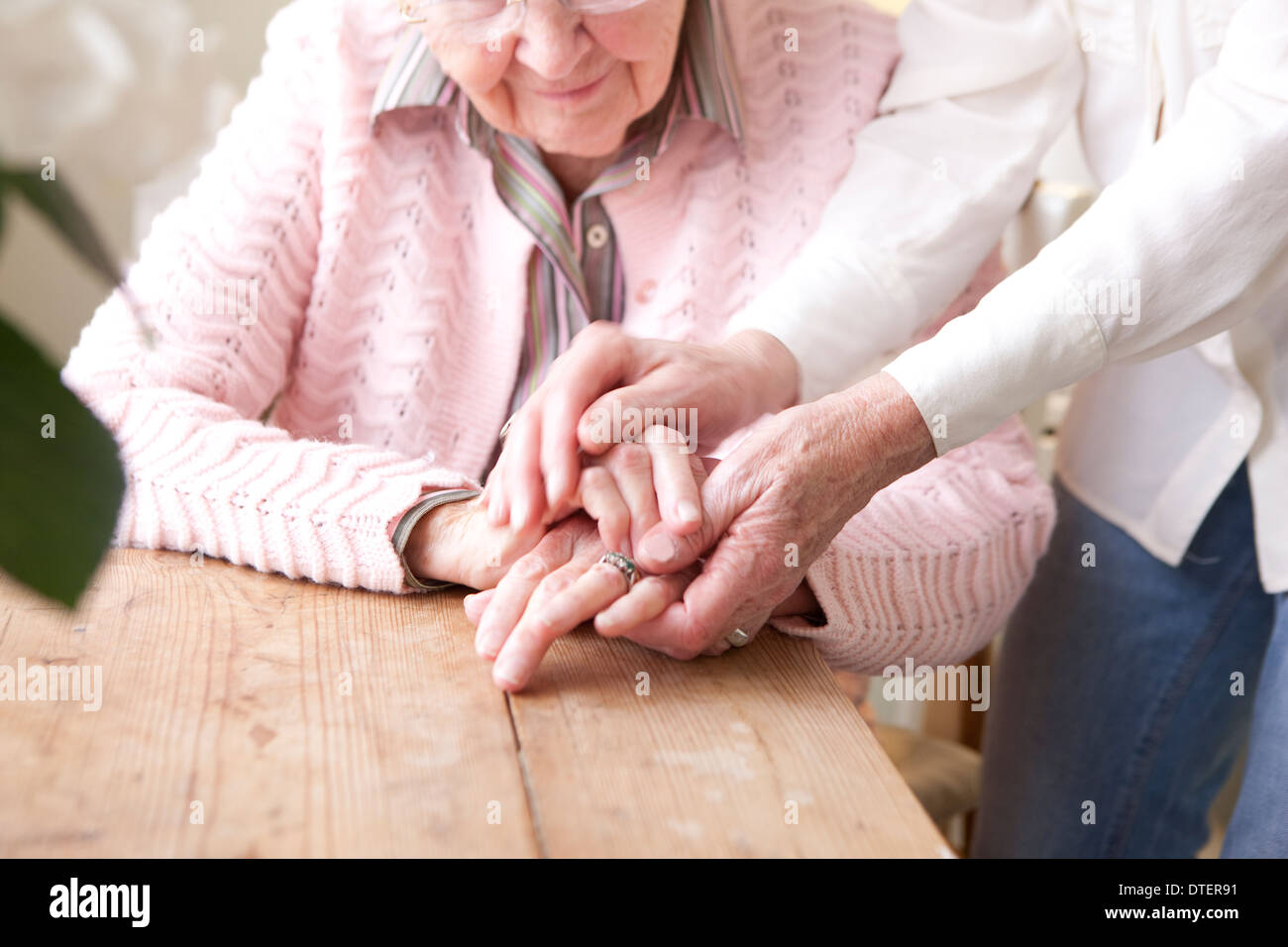 Close-up of hands of mature woman holding hands of elderly woman Stock Photo