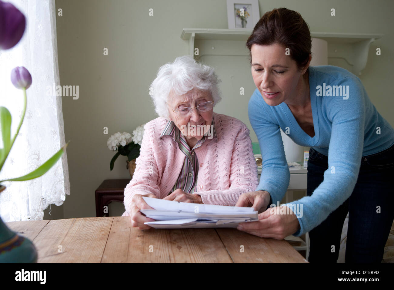 Elderly woman and caregiver reading document Stock Photo