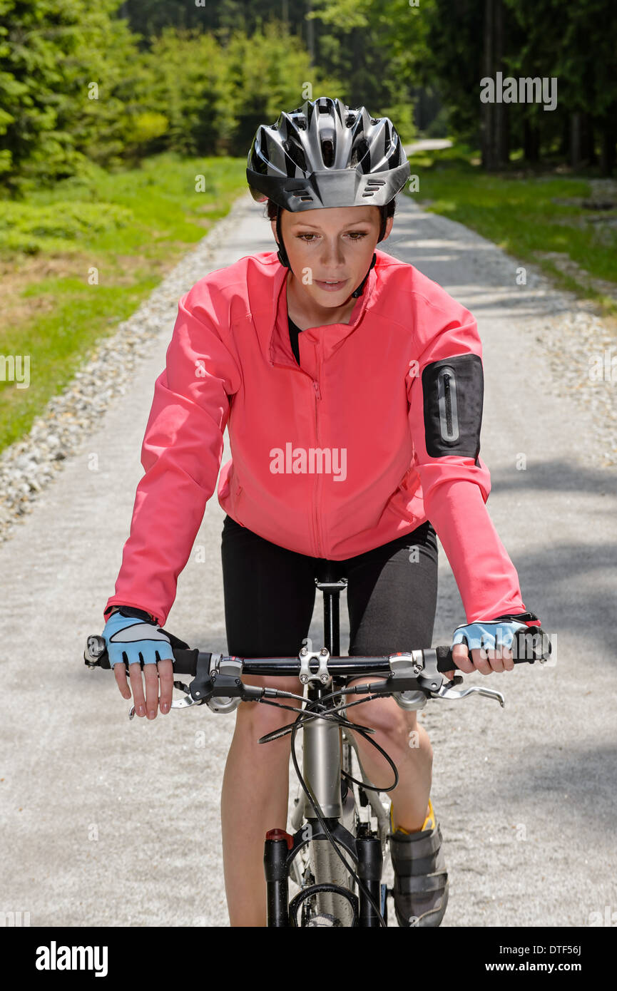 Woman riding mountain bike on sunny countryside cycling path Stock Photo