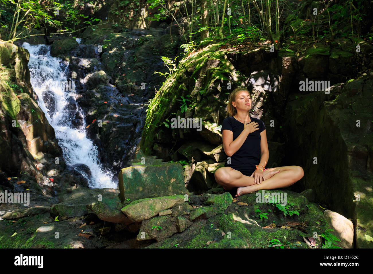 Young woman enjoying in yoga pose in Waterfall Stock Photo - Alamy
