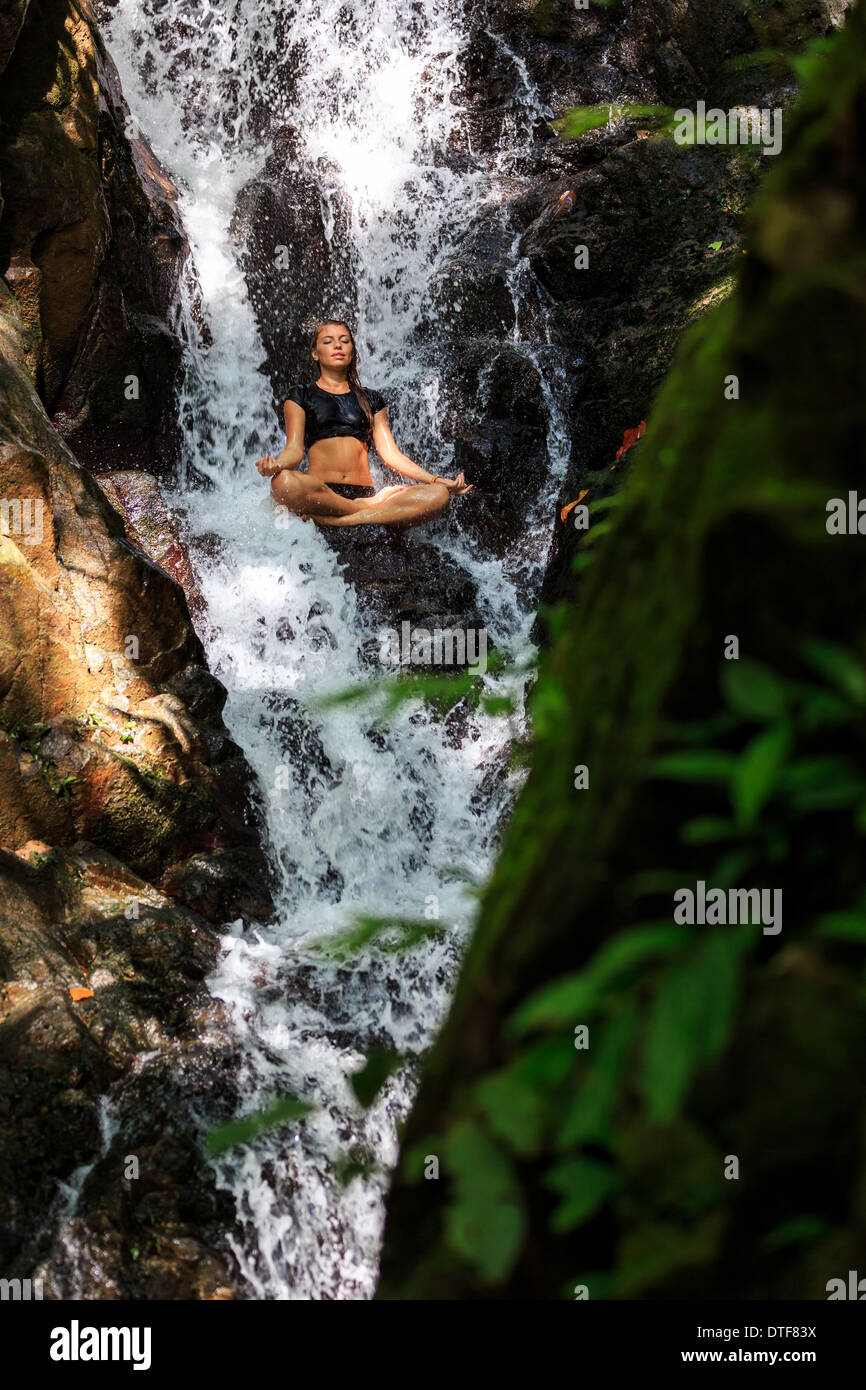 Young woman enjoying in yoga pose in Waterfall Stock Photo - Alamy