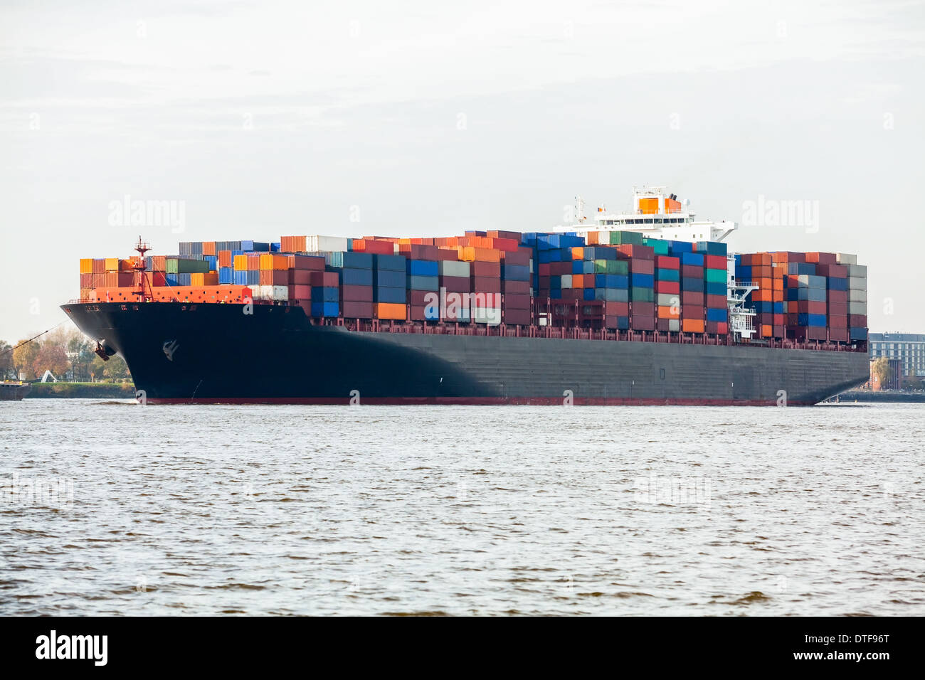Fully laden container ship in port with its decks stacked with metal containers full of freight