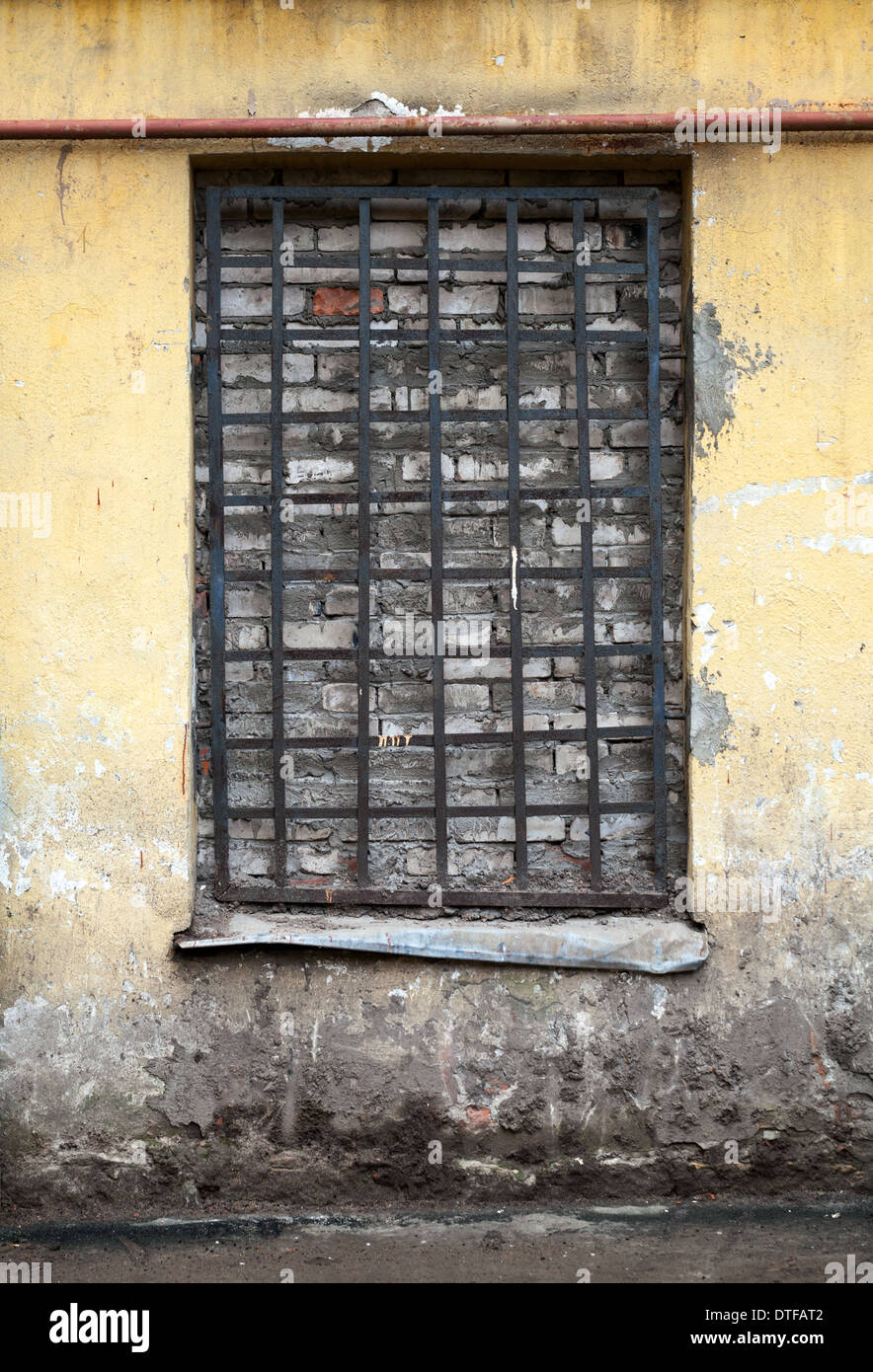 Old yellow building facade with locked window Stock Photo